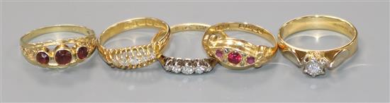 Four assorted 18ct gold and gem set rings and one yellow metal and gem set ring.